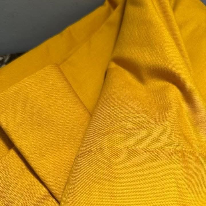Close-up of yellow fabric with a textured pattern