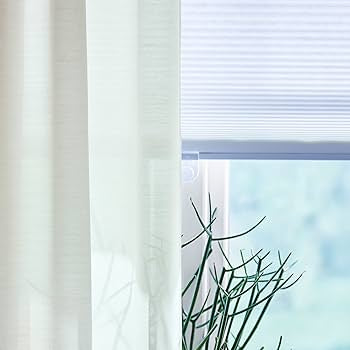 White semi-sheer 100% polyester curtains hanging on a rod close up texture